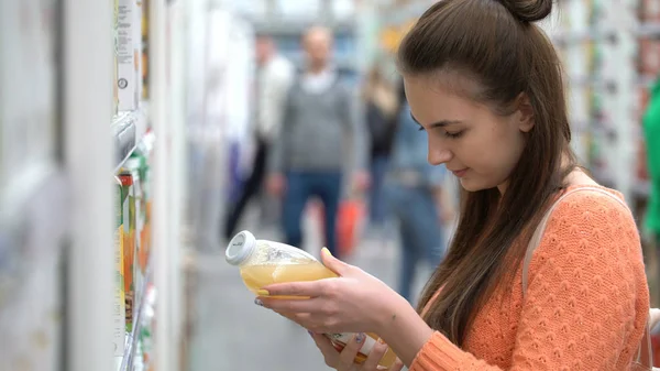 Женщина покупает сок в супермаркете . — стоковое фото