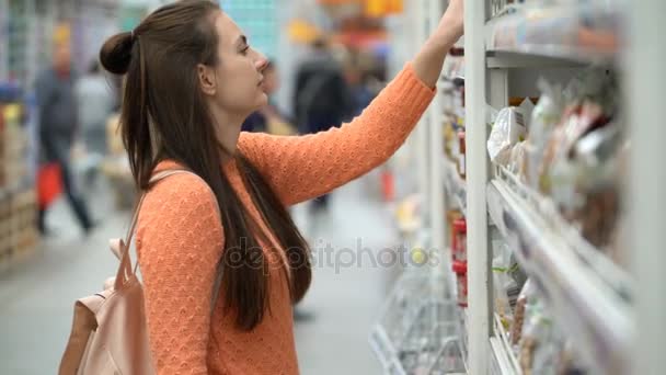 Meisje koopt een jam in een winkel. — Stockvideo