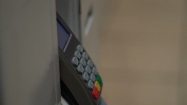 Bir kadın Terminal bir banka kartı ile satın almak için ödediği.