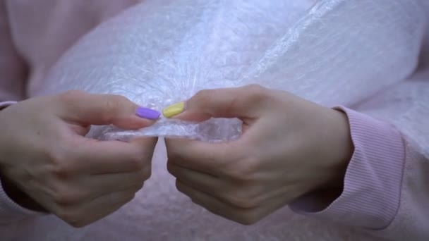 A woman presses a bubble wrap. — Stock Video