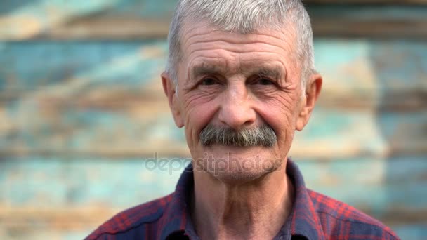 Retrato de un anciano sobre un fondo de pared de madera . — Vídeo de stock