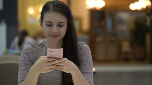 Mujer joven escribiendo un mensaje en su teléfono inteligente . — Vídeos de Stock