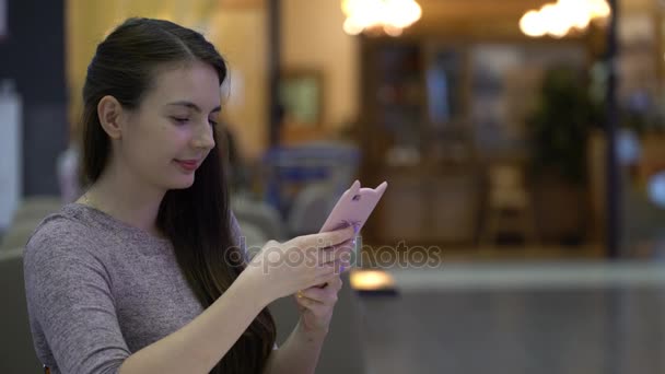 Jovem mulher digitando uma mensagem em seu smartphone . — Vídeo de Stock