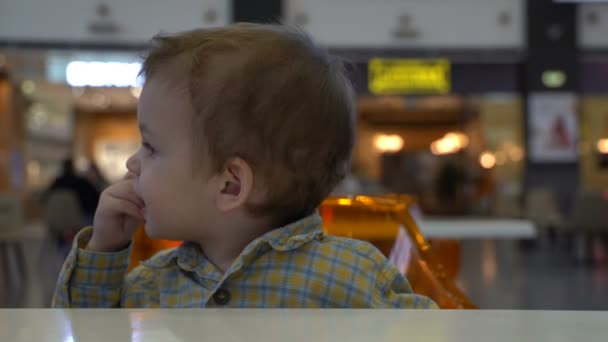 Jovem menino comendo batatas fritas na praça de alimentação . — Vídeo de Stock