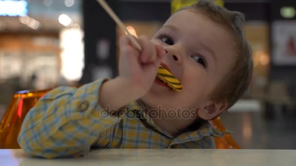 Little boy eating lollipop. — Stock Video