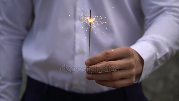 Young businessman in blue suit holds a bengal fire in his hand. — Stock Video