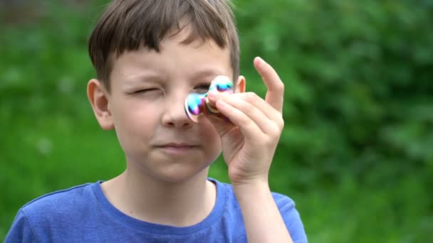 Pojke leker med spinner utomhus. 4k-video. — Stockvideo