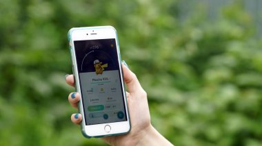 Samara, Rusya Federasyonu - 7 Temmuz 2017: kadın oyun pokemon onun iphone 6s artı gidin. Pokemon artar gerçeklik unsurları ile multiplayer oyun gidin. Pikachu Ashs Cap.