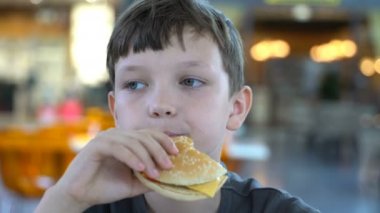 siyah bir burger yakın çekim çocuk yiyor.
