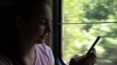 Kız tren ile seyahat ve onun smartphone uygulama kullanır.