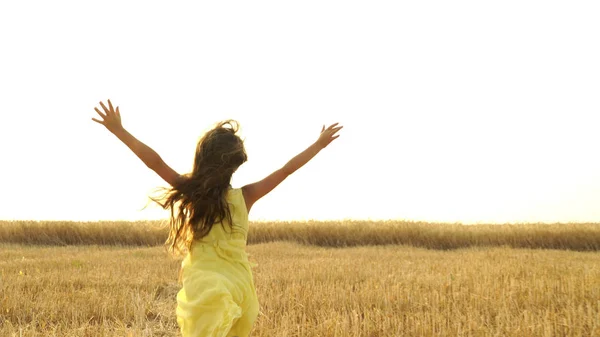 Giovane ragazza in abito sta correndo attraverso il campo . — Foto Stock