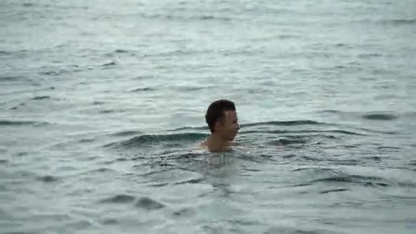 Ein Teenager schwimmt im Meer. — Stockvideo