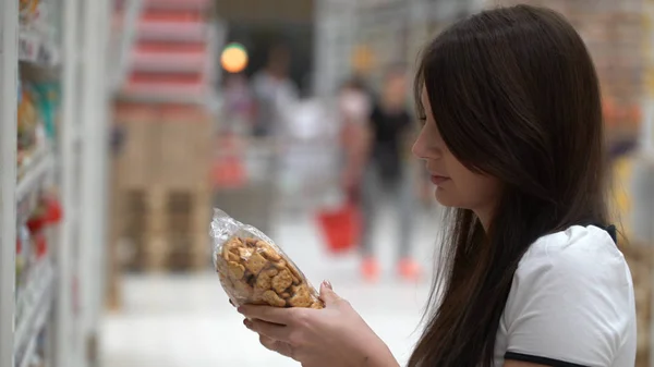 Девушка покупает печенье в магазине или супермаркете . — стоковое фото
