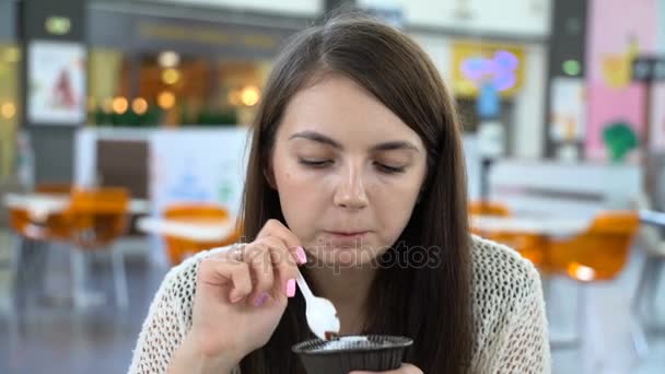 Flicka äter brownie med glass på ett café. — Stockvideo