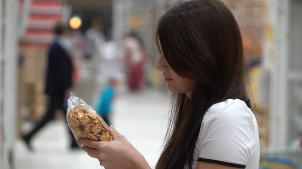 Flicka köper cookies i en butik eller stormarknad. — Stockfoto