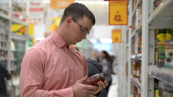 A fiatal srác úgy dönt, egy ecetes-sós zöldségek egy boltban, vagy szupermarket. — Stock Fotó