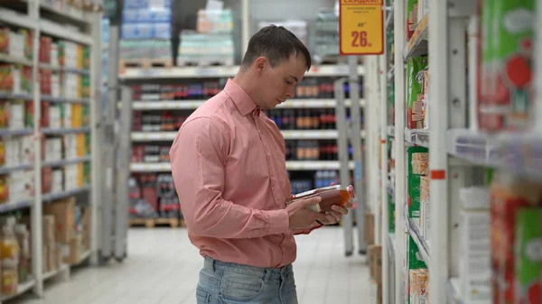 Chico joven compra jugo en una tienda o supermercado . — Foto de Stock