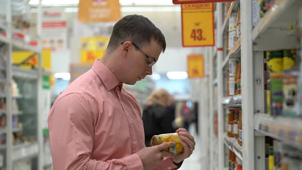 Joven chico elige un encurtido verduras en una tienda o supermercado . — Foto de Stock