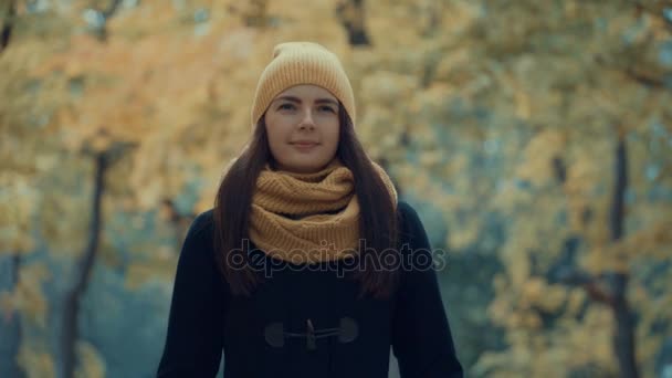 Nuori tyttö kävelee puistossa syksyllä . — kuvapankkivideo
