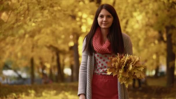 Muchacha joven camina en el parque en otoño . — Vídeos de Stock