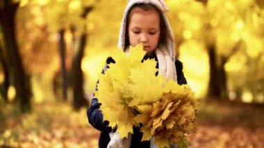 Kız yedi yıl sonbaharda bir parkta yürüyor ve yaprakları onun elinde tutan