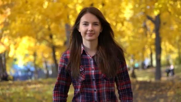 Молода дівчина гуляє в парку восени . — стокове відео