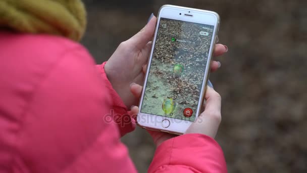 Samara, Federacja Rosyjska - 28 listopada 2017: Kobieta draconius gry przejść na jego iphone. draconius go multiplayer gra z elementami rzeczywistości rozszerzonej — Wideo stockowe