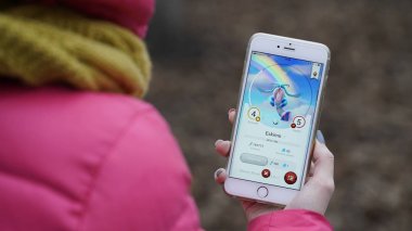 Samara, Rusya Federasyonu - 28 Kasım 2017: kadın oynarken draconius onun iphone gidin. draconius Artırılmış gerçeklik unsurları ile çok oyunculu oyun gitmek