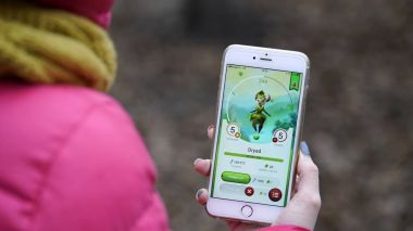 Samara, Rusya Federasyonu - 28 Kasım 2017: kadın oynarken draconius onun iphone gidin. draconius Artırılmış gerçeklik unsurları ile çok oyunculu oyun gitmek