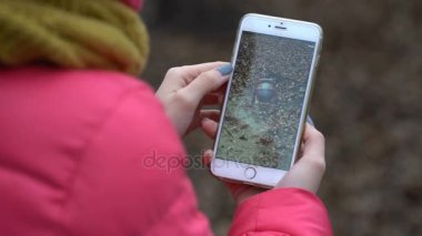 Samara, Rusya Federasyonu - 28 Kasım 2017: kadın oynarken draconius onun iphone gidin. draconius Artırılmış gerçeklik unsurları ile çok oyunculu oyun gitmek