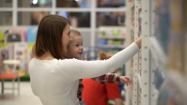 Ung mamma och son köpa vatten i en butik eller stormarknad. — Stockvideo