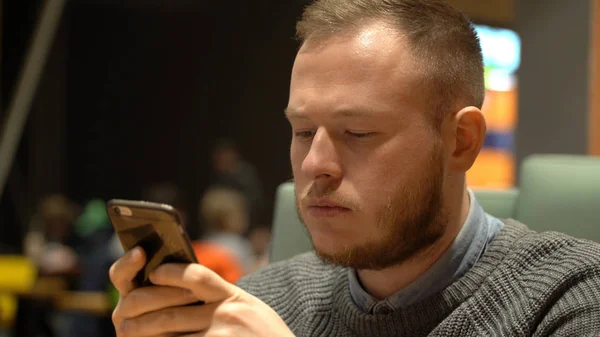 Joven empresario utiliza la aplicación de redes sociales en su teléfono inteligente . — Foto de Stock