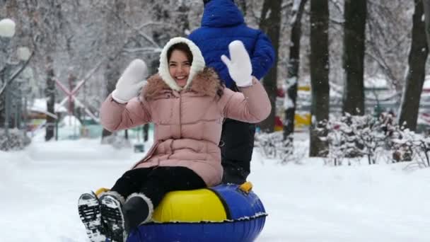 Junges Mädchen rollt im Winter auf Schläuchen im Park. — Stockvideo