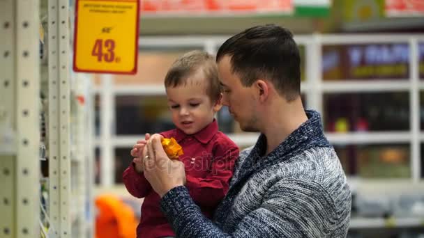 Батько і син купують рідке мило в магазині або супермаркеті . — стокове відео
