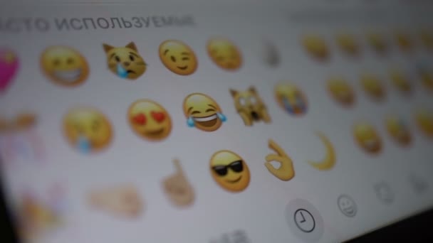 Hombre mira los iconos emoji en un teléfono inteligente — Vídeo de stock