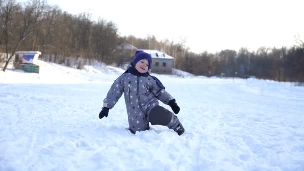 Zweijähriger Junge wandert im Winter. — Stockvideo