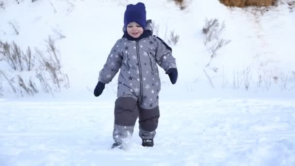 Pojke på två år promenader i vinter. — Stockvideo