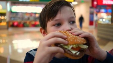 Oğlum bir hamburger yiyor yakın çekim.