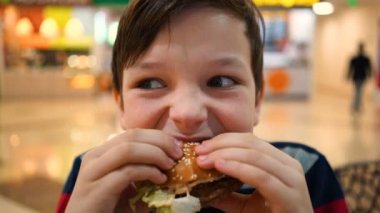 Oğlum bir hamburger yiyor yakın çekim.