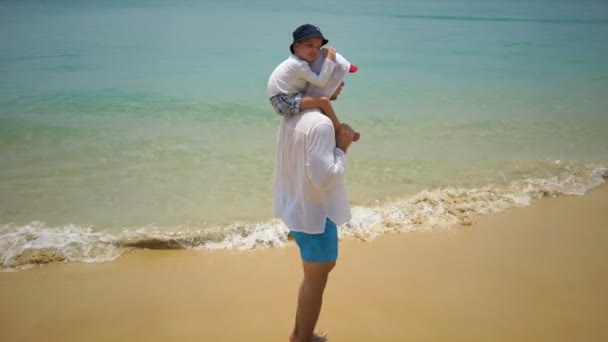 Отец и сын, идущие пешком вдоль пляжа возле океана . — стоковое видео