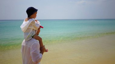 Baba ve oğul Okyanusu yakınlarındaki sahil boyunca yürüyerek dolaşıyor.