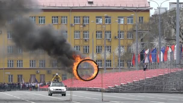 Самара, Россия - 1 мая 2018 года: каскадер едет по крыше автомобиля и прыгает в горящее кольцо — стоковое видео