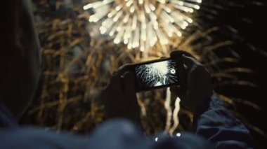 Fireworks gece gökyüzüne fotoğraf çekimi bir adam silüeti. Tatil onuruna güzel Selam.