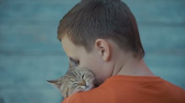 genç adam bir kedi okşayarak.