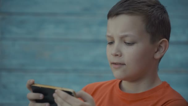 Jonge tiener speelspel op smartphone — Stockvideo