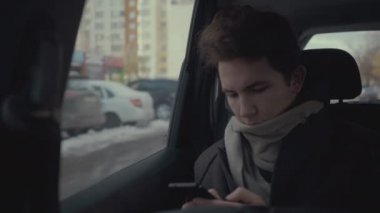 Genç çocuk Smartphone kullanarak şehirde taksi yolculuğu sırasında
