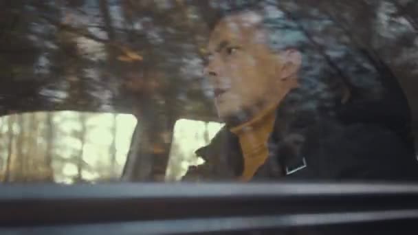 Man rides a car on the Country road. Trees reflected in car window — Stock videók