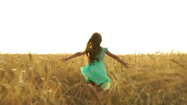 Junges Mädchen im Kleid rennt über das Feld. — Stockfoto