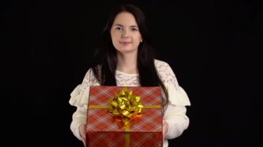 Siyah arka planda hediye kutusu olan genç bir kadın. Mutlu yıllar için beyaz kurdeleli hediye kutusu, Mutlu Noeller, Sevgililer Günü, doğum günü.