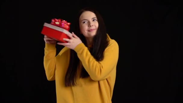 Mladá žena s dárkovou krabicí na černém pozadí. dárková krabička s bílou stuhou na Šťastný Nový rok, Veselé Vánoce, Valentýn, narozeniny. — Stock video